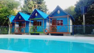 a set of three play houses next to a swimming pool at Villa Marlen Palomino in Palomino