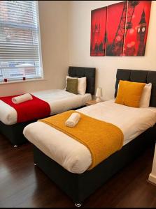 two beds sitting next to each other in a room at Elite Wolverhampton short/long stays in Wolverhampton