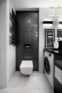 La salle de bains est pourvue de toilettes et d'un lave-linge. dans l'établissement AMK Apartament 12 Premium Gdynia Centrum, à Gdynia