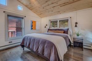 a bedroom with a large bed and two windows at Cozy Modern House seconds from Roaring Fork River in Glenwood Springs