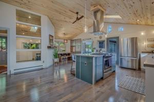 a large kitchen with wooden ceilings and a wooden floor at Cozy Modern House seconds from Roaring Fork River in Glenwood Springs