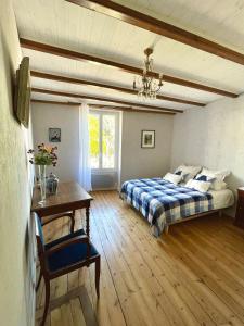 a bedroom with two beds and a table in it at Chez Sarah - L'Escapade in Javerlhac-et-la-Chapelle-Saint-Robert