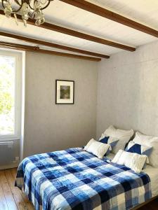 a bedroom with a blue and white checkered bed at Chez Sarah - L'Escapade in Javerlhac-et-la-Chapelle-Saint-Robert
