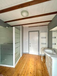 a bathroom with a white sink and a wooden floor at Chez Sarah - L'Escapade in Javerlhac-et-la-Chapelle-Saint-Robert