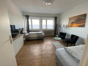- une chambre avec un lit, une télévision et un canapé dans l'établissement Monteurhaus Hemelingen, à Brême