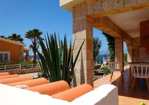 a patio with chairs and a plant next to a building at Villa Atum. Stella Maris Exclusive in Vila do Maio