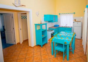 eine Küche mit blauen Schränken und einem Tisch darin in der Unterkunft Villa Atum. Stella Maris Exclusive in Vila do Maio