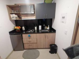 una pequeña cocina con fregadero y microondas en Moderno Apartamento Chapinero Bogota, en Bogotá