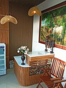 Habitación con escritorio y jarrón de flores. en The Cabin Hotel Ambasador en Yogyakarta
