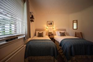 2 Einzelbetten in einem Zimmer mit Fenster in der Unterkunft Balmridge House, Loch Ness, Bed & Breakfast in Drumnadrochit
