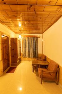 a living room with a couch and a wooden ceiling at Vivaan Stays -Holiday Home International in Manāli