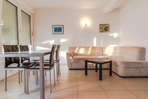 ein Wohnzimmer mit einem Sofa, einem Tisch und Stühlen in der Unterkunft Vila Lavanda in Neum