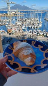 eine Person, die einen Teller Essen mit einem Yachthafen hält in der Unterkunft coraline in Castellammare di Stabia