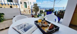 een tafel met een dienblad met eten op een balkon bij Cristina Studio Apartment in Póros