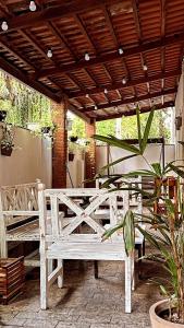 un banco de madera sentado bajo un pabellón en un patio en Hotel Rio, en Guarujá
