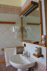 a bathroom with a white sink and a mirror at affittacamere la torre in Tegoleto
