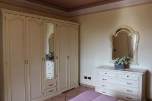 a bedroom with white cabinets and a white dresser at affittacamere la torre in Tegoleto