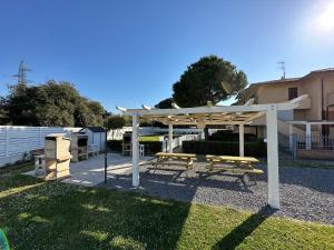 a picnic shelter with two benches in a yard at Villaggio Mietta in Castiglioncello