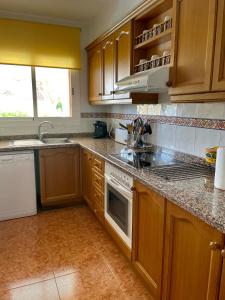 a kitchen with wooden cabinets and a stove top oven at Los Alamos Somhome in Peniscola