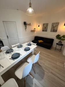 sala de estar con mesa blanca y sillas en Appartement spacieux - proche centre et therme en Bagnères-de-Bigorre