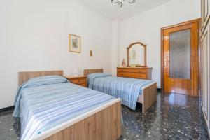 um quarto com 2 camas, uma cómoda e um espelho em 104 - Casa Tulipano Riva Trigoso, a due passi dal mare - Posto auto privato gratis em Riva Trigoso