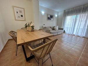 sala de estar con mesa de madera y sillas en Apartamentos LOS TULIPANES en Salou