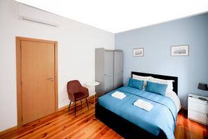 1 dormitorio con 1 cama azul y 1 silla en Lisboa Sweet Family Homestay, en Lisboa