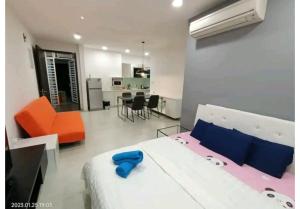 Cet appartement comprend une chambre avec un lit et une chaise orange ainsi qu'une cuisine. dans l'établissement City Town 2-6 Pax Beautiful View Cozy Condo, Jelutong, Georgetown, Centre Heart Of Penang Island, near Highway Komtar Gurney, à George Town