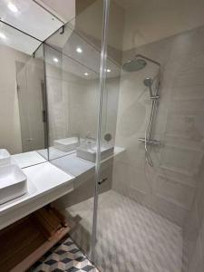 een badkamer met een glazen douche en een wastafel bij Downtown collection apartments in Funchal