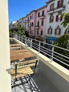 2 houten tafels en stoelen op een balkon met gebouwen bij Downtown collection apartments in Funchal