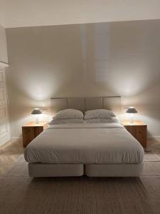 een slaapkamer met een wit bed met 2 nachtkastjes en 2 lampen bij Downtown collection apartments in Funchal