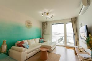 a living room with a couch and a large window at Sunset Resort 507 in Fonyód