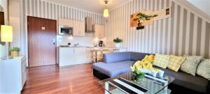 ザコパネにあるTATRAHOLIDAY - Apartament Kieżmarski Szczyt - SPAのソファとキッチンのあるリビングルーム