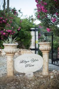 a sign in front of a gate with two potted plants at Likya Yolu Palas Hotel in Kapaklı