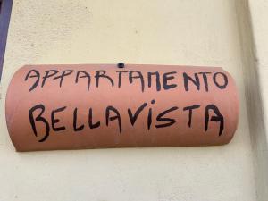 a pink sign on a wall with writing on it at Appartamento Bellavista in Saline