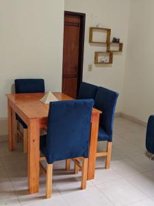 una mesa de madera con sillas azules en una habitación en Colibri Apart Eldorado en Eldorado