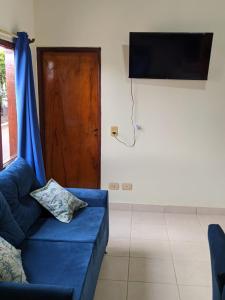 sala de estar con sofá azul y TV en Colibri Apart Eldorado en Eldorado