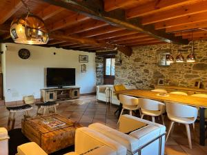 a large living room with a table and a tv at Casa Rural O Vilar in Mera de arriba