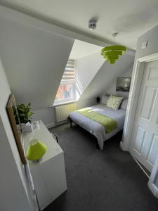 a bedroom with a bed and a yellow lamp at Rivendell Holiday Studios & Suite in Swanage