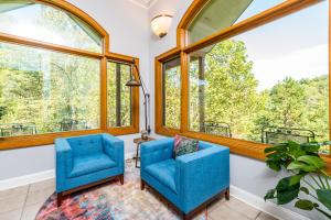 - deux chaises bleues dans une chambre avec de grandes fenêtres dans l'établissement Villa at Stony Woods Estate mountain luxury near Asheville, à Marshall