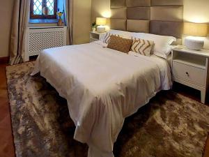a bedroom with a large white bed and a window at Villa Segreta, Mount Etna in Belpasso