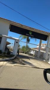 a gate in front of a building with a fence at Apto com estacionamento, piscina e churrasqueira in Bragança Paulista