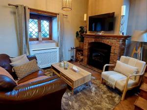 a living room with a leather couch and a fireplace at Villa Segreta, Mount Etna in Belpasso