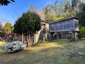 Mera de arriba的住宿－奧維拉爾鄉村民宿，院子里有树的石头房子
