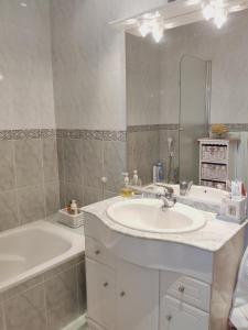 biała łazienka z umywalką, wanną i tubermotem w obiekcie Chalet en Valle del Tietar w mieście Lanzahita