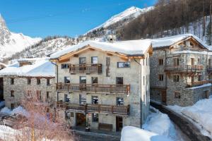 a large building with snow on the roof at Chalet Hotel Du Fornet in Val dʼIsère