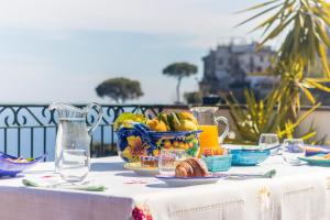 a table with a plate of food and a bowl of fruit at Via Col Vento in Ravello