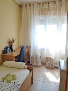 1 dormitorio con cama, escritorio y ventana en Chalet en Valle del Tietar, en Lanzahita