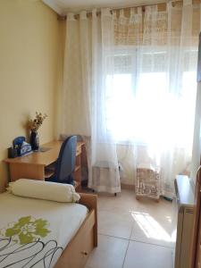 sypialnia z łóżkiem, biurkiem i oknem w obiekcie Chalet en Valle del Tietar w mieście Lanzahita