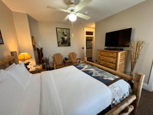 a bedroom with a large bed and a flat screen tv at Historic Branson Hotel - Hide-A-Way Room with Queen Bed - Downtown - FREE TICKETS INCLUDED in Branson